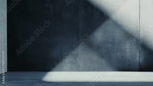 Empty concrete room with minimalist modern architecture, light streaming from an unseen opening to cast bold geometric highlights and deep shadows across textured walls and floor