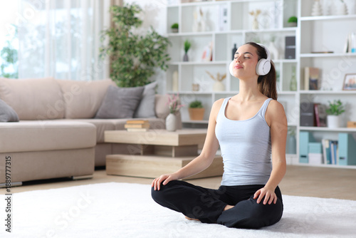 Fotografija Woman doing yoga guided breathing exercise at home
