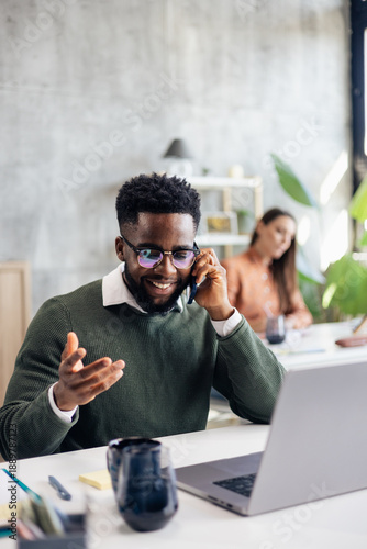 Engaging businessman talking on phone in modern office