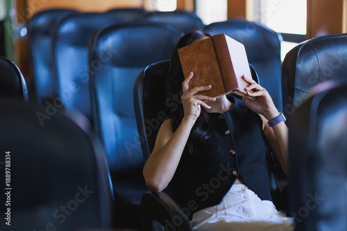 Billede på lærred Woman sleeping deeply covering face with book while traveling