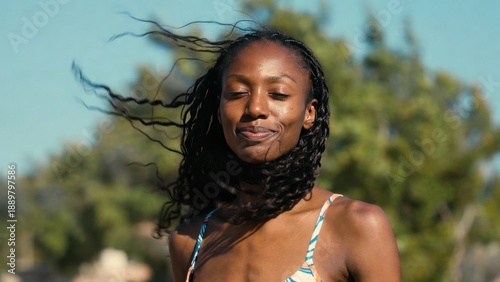 Smiling african female adult with windblown hair outdoors