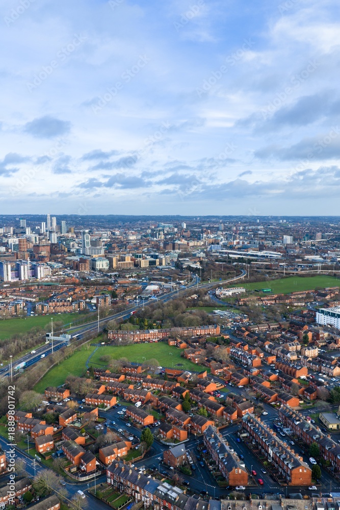 Obraz premium Portrait aerial drone photo of the city centre of Leeds West Yorkshire in the UK showing the British town centre on a cold day in the winter time and rows of houses with the motorway close by