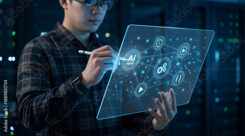 Focused man interacts with AI agent on glowing transparent screen in dark server room with blue light