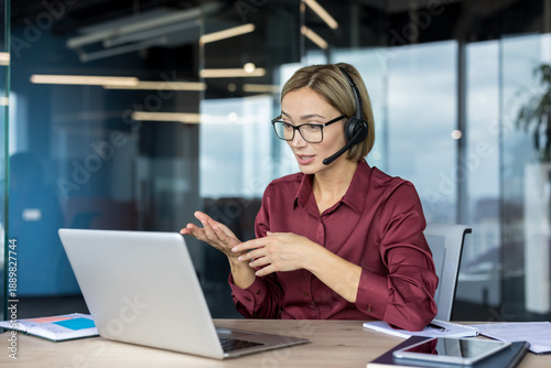 Foto Businesswoman with glasses and headset having a video call discussion, gesturing