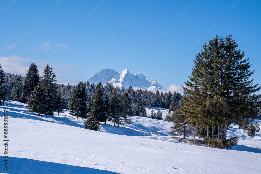 Obraz premium Snow-covered Buckelwiesen near Mittenwald set within the winter alpine mountains.