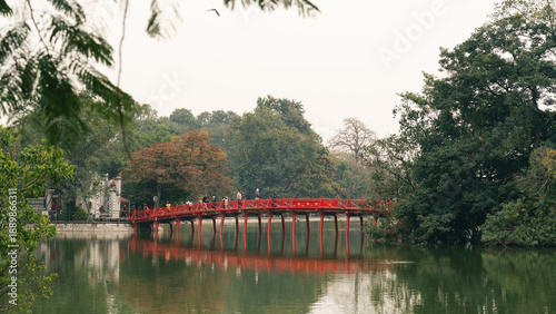 Obraz na płótnie The iconic red bridge spans the tranquil lake surrounded by lush greenery nature