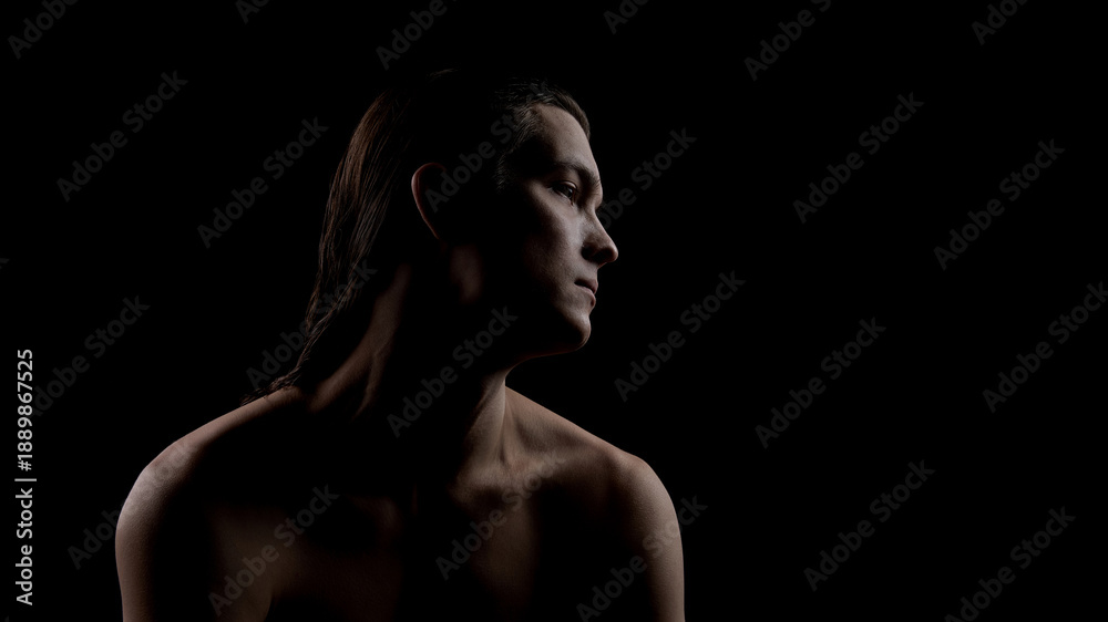 Fototapeta premium Male profile portrait in shadow highlighting face and neck skin. Concept of men facial skincare, skin protection, daily grooming routine, and confident minimal lifestyle.