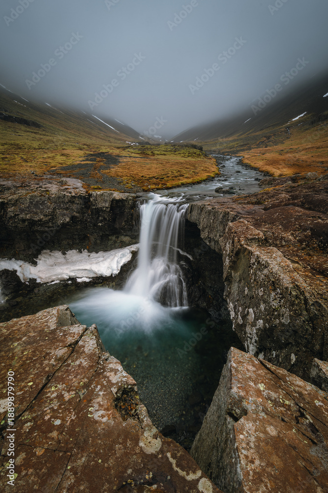 Fototapeta premium Beautiful Skutafoss waterfall flowing near Hofn. Scenic Icelandic nature with a stream falling over rocky terrain in the East Fjords.