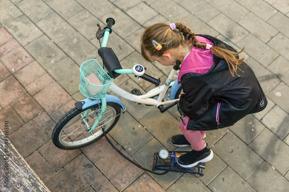 Obraz premium Father and nine year old child pumping wheels of a kid's bicycle outdoors, family activity and childhood