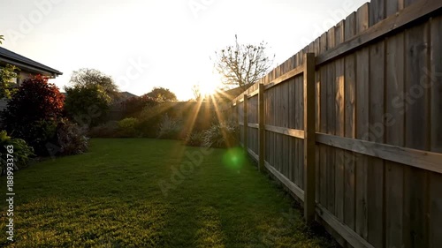 Sunset over backyard with wooden fence.