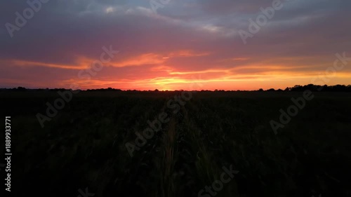 Sunset over landscape with cloudy sky.