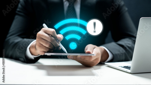 A businessman in a suit holding a tablet that displays a glowing blue Wi-Fi icon with an exclamation mark warning sign, indicating no internet connection or technical connectivity issues