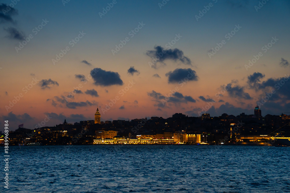 Fototapeta premium Karakoy district with Galata tower at sunset, sea view. Evening cruise on Bosphorus. Istanbul, Turkey.