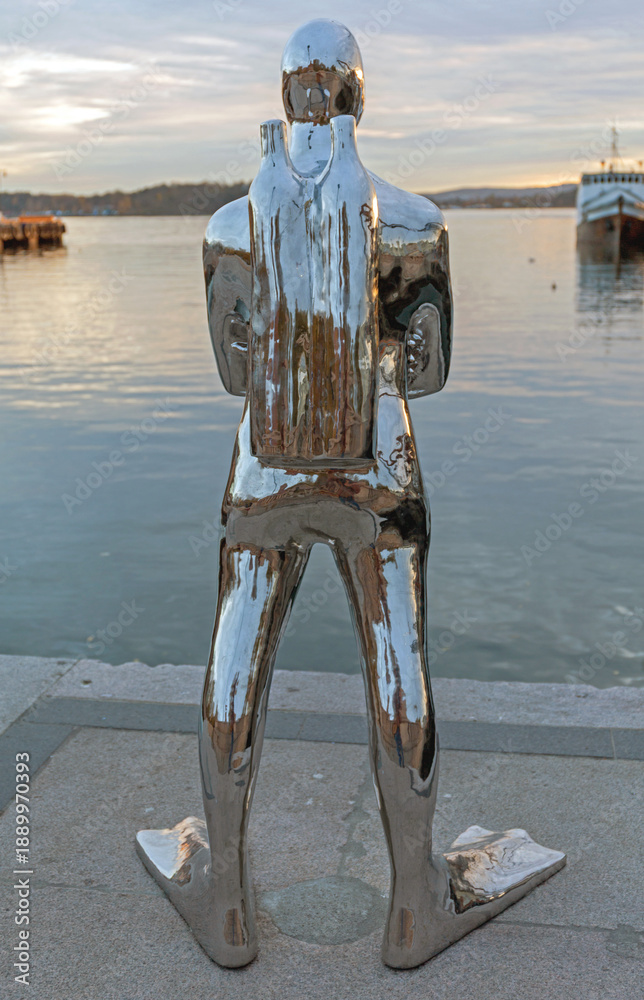Fototapeta premium Silver Statue of Diver at Dock in Oslo Norway Autumn Afternoon