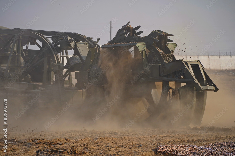 Fototapeta premium Military special equipment digs a trench in a field. Military exercises.