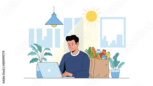 Productive man works on his laptop at a clean white desk next to a large paper grocery bag filled with healthy vegetables and bread.