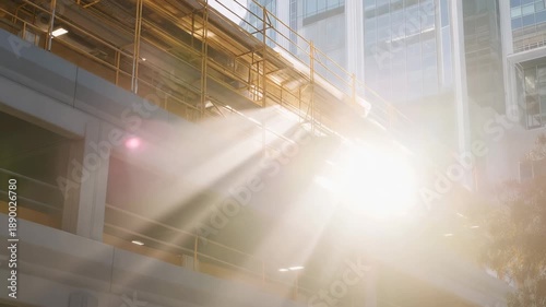A construction crew renovating the upper level of a parking garage, scaffolding and dust catching sunbeams through open concrete patterns — infrastructure maintenance, urban development, and raw