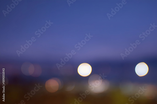 夜景の輝きが作り出す紫と青の幻想的な玉ボケ背景