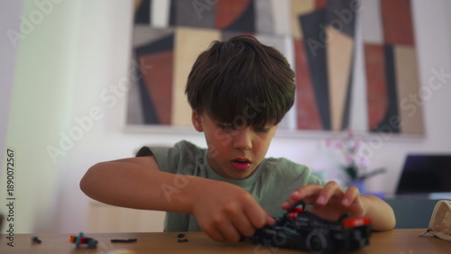 Fotografia Young boy playing with toy race car on table, focused and engaged in hands on ac
