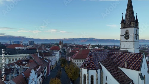 30 october 2024, Sibiu, Romania. Sunrise, forward drone flight Piaţa Albert Huet square, Sibiu Lutheran Cathedralat sunrise. Beautiful  touristic must-see destination. mountains, travel destination.