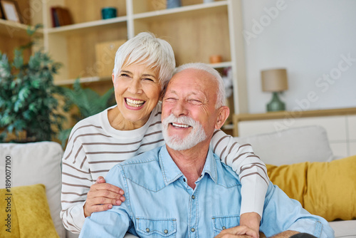 Happy active senior couple, portrait of an elderly woman with her husband sitting at home