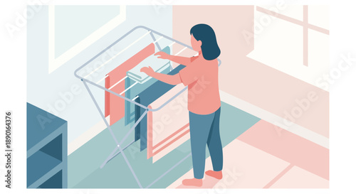 Woman standing indoors drying laundry on a rack beside a sunlit window.