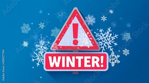 Winter weather warning road sign with exclamation mark and snowflakes, red triangle symbol on pole against blue sky, falling snow showing cold season traffic hazard and safety caution