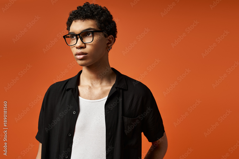 Obraz premium Stylish young man in glasses shows off modern fashion in a vibrant studio