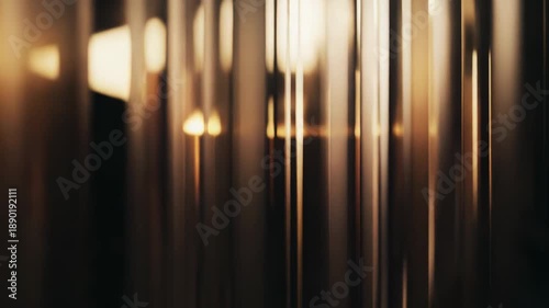 Abstract vertical lines forming a modern background texture with warm golden light reflections, creating an atmospheric backdrop for design and luxury concepts