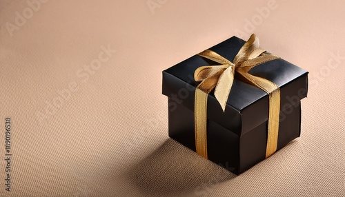Black Gift Box With Gold Ribbon On Beige Surface
