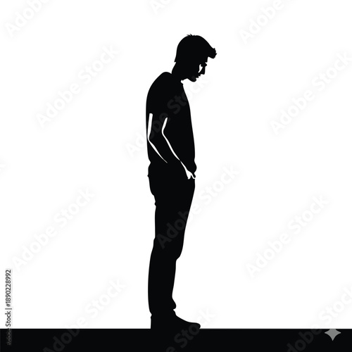 Young man in silhouette looking down with hands in pockets, conveying introspection.
