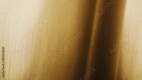 Abstract background featuring soft golden light merging into warm brown shadows with a subtle flowing texture, creating a tranquil and elegant visual experience