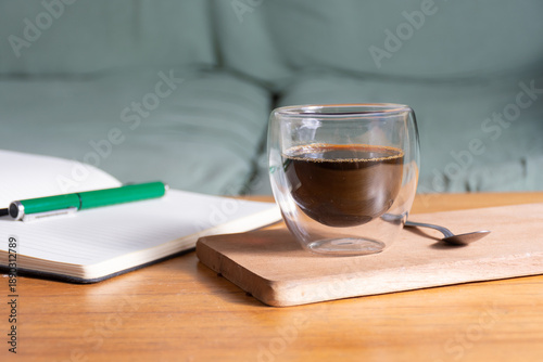 Obraz na płótnie A moment of reflection with a cup of coffee and a notebook in the living room armchair