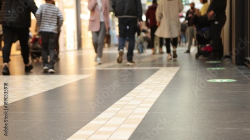 people walking, shopping mall, crowd walking. Crowd of people in mall during shopping time, close up of legs holding shopping bags, selective focus, modern floor and crowd walking along it