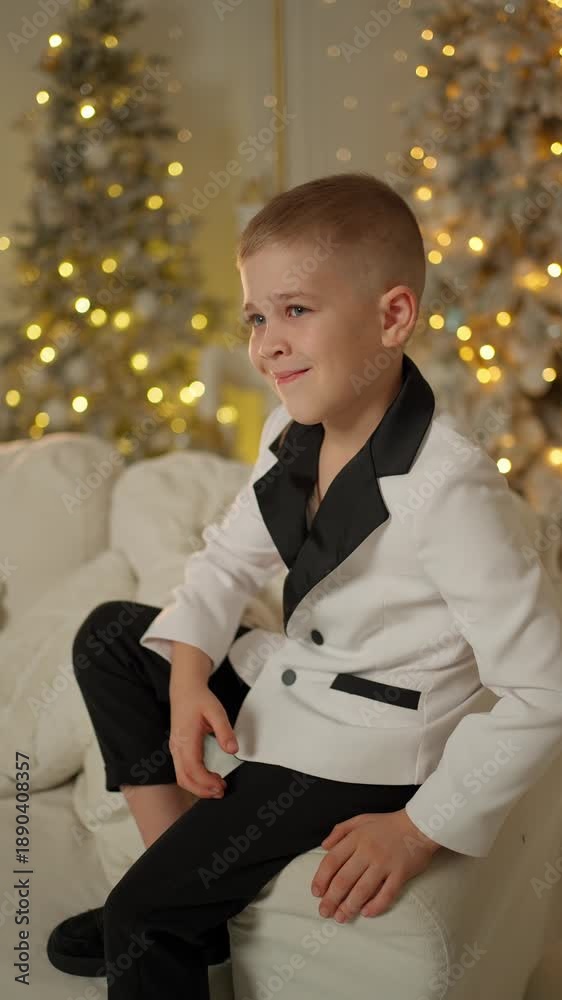 custom made wallpaper toronto digitalSmiling boy in a stylish suit sitting on the sofa. New Year celebration concept.