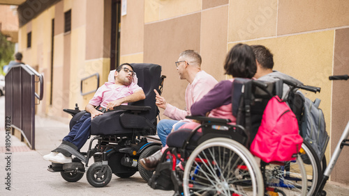 Tableau sur toile Group of adults with physical disabilities using wheelchairs and talking outdoor