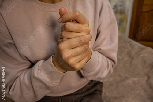Close-up of hands clasped together, conveying worry or discomfort