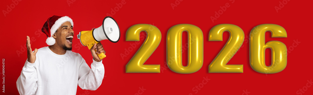 Naklejka premium A person is excitedly shouting using a megaphone. He is wearing a santa hat and signaling the celebration of the year 2026. The background is bright red with large yellow numbers.