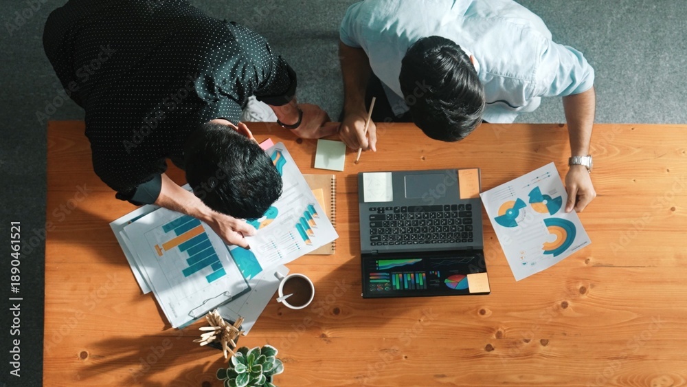 Naklejka premium Skilled project manager walking at table while colleague brainstorm idea. Business team working together to plan marketing strategy while looking at data analysis or financial statistic. Convocation.