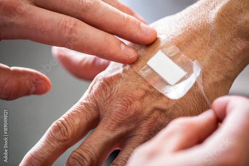 Εκτύπωση καμβά A close up of nurses hands applying a hydrocolloid bandage onto an elderly perso