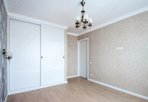 Empty modern apartment room with white wardrobe and wooden floor