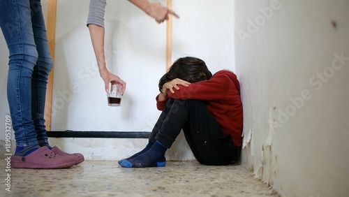 Child cowering in fear during parental verbal abuse and alcoholism, experiencing domestic violence, neglect, and trauma in a distressed home environment