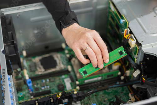 Foto Adult male IT technician installs and upgrades server hardware inside a computer