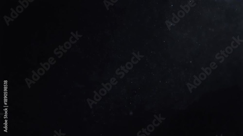 Close-up of micro dust particles floating slowly in dark background with ethereal light glimmers, creating atmospheric haze overlay