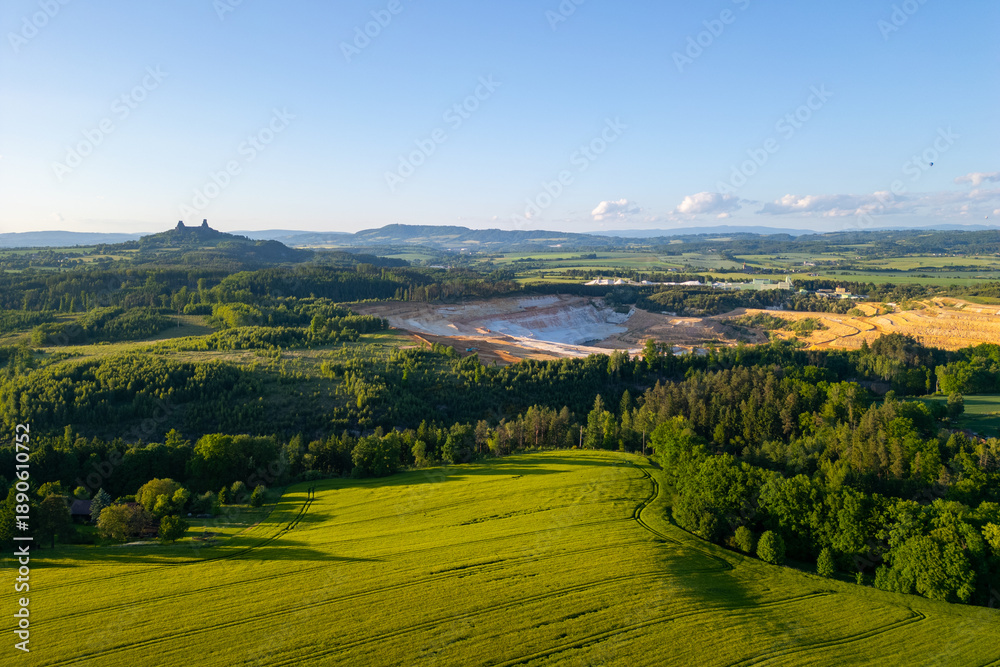 Obraz premium Trosky Castle set against a vast countryside during summer in Bohemian Paradise. Green fields and distant hills create a beautiful landscape in Czechia.