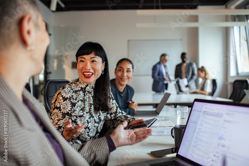 Diverse coworkers collaborating during team meeting in modern office