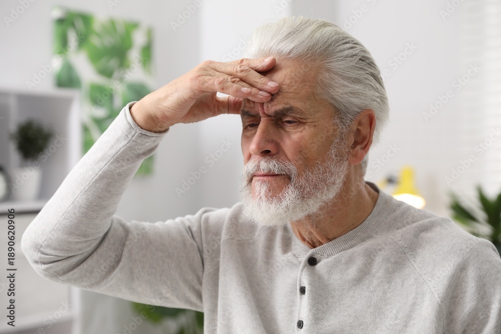 Obraz premium Amnesia. Senior man trying to remember something at home