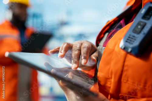 Obraz na płótnie Close up of offshore platform worker supervising deck operations with device, ensuring compliance with safety protocols