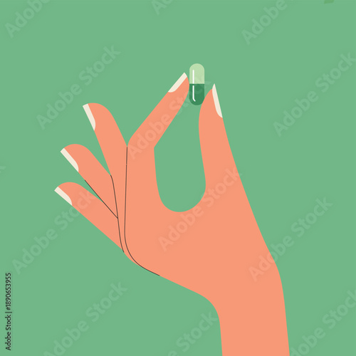 A hand holding a green and white capsule on a green background