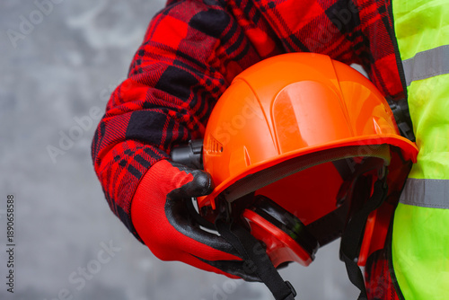 Fényképezés Professional construction worker is holding a safety helmet with earmuffs